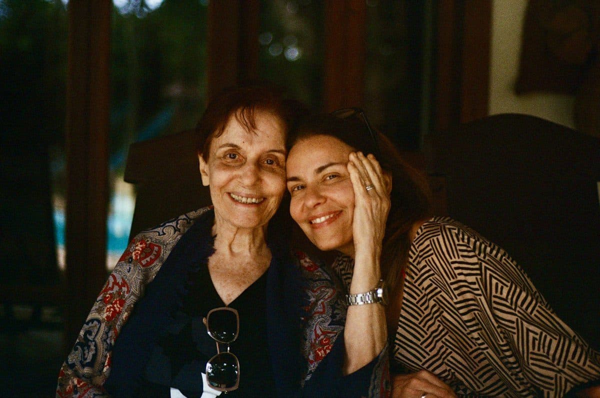 A mother and her adult daughter sharing an embrace at home