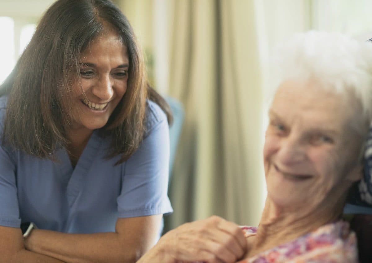 A caregiver smiling with an elderly resident